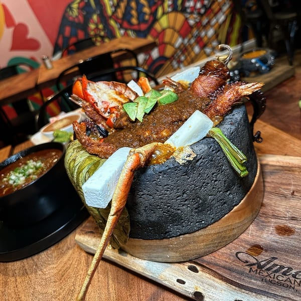A molcajete dish from AMELIAS MEXICAN KITCHEN, with lobster, shrimp, avocado, and sauce.