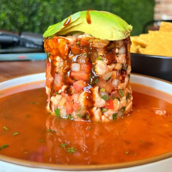 Amelia's Mexican Kitchen's ceviche tower with avocado, shrimp, tomatoes, onions, and cilantro in red sauce.