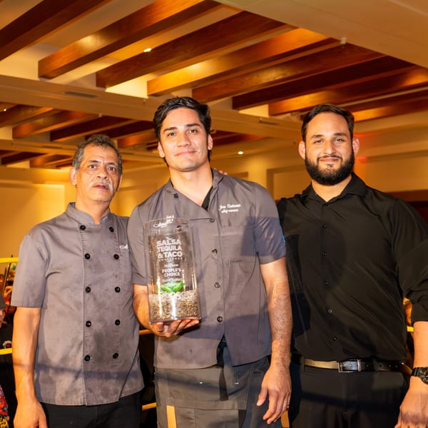 Three men, including Amelia's Mexican Kitchen's Chef Jose Contreras, pose with a "Best Salsa" award.