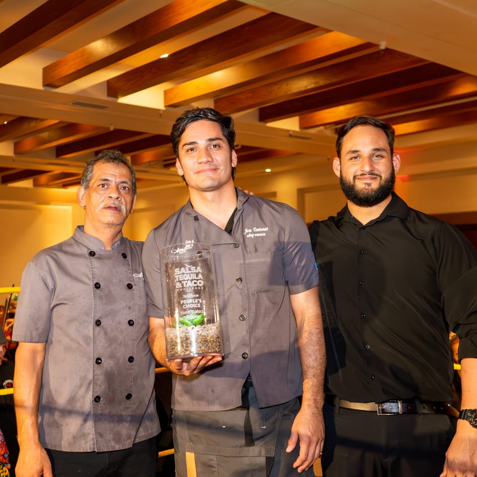 Three men, including Amelia's Mexican Kitchen's Chef Jose Contreras, pose with a "Best Salsa" award.